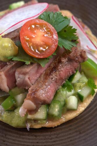 a sandwich with meat and vegetables on a plate at Amaranto Bacalar Hotel Boutique in Bacalar