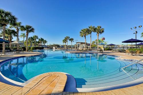 a large swimming pool with palm trees in a resort at Summer is Calling - Disney Close - No Resort Fees in Orlando