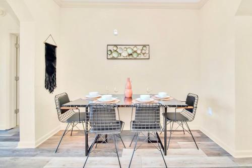 una mesa de comedor con sillas y un jarrón. en Modern 2BR Condo - Hot Tub and Pool - Near Disney, en Orlando