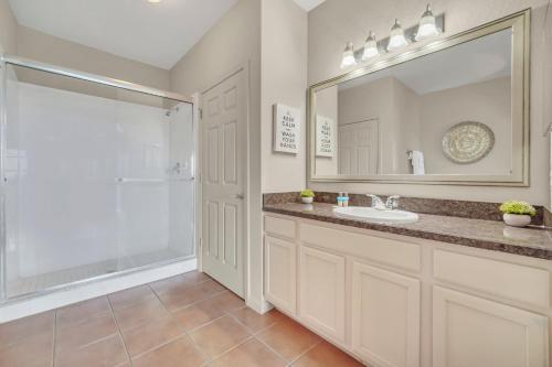 a bathroom with a sink and a shower and a mirror at 2BR Condo with Hot tub and pool, near Disney! in Orlando