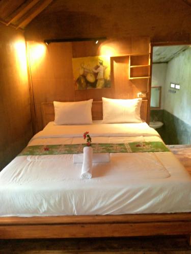 a bedroom with two beds with a vase of flowers on it at Bintang Homestay in Tetebatu