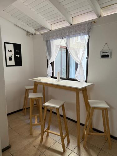 una mesa con cuatro taburetes en una habitación con ventana en House Mendoza - Apartamento de 2 plantas, en Mendoza