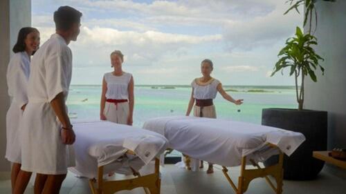 a group of people standing next to beds on the beach at Amaranto Bacalar Hotel Boutique in Bacalar