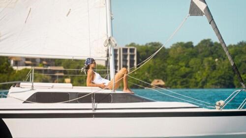 a woman sitting on a sail boat in the water at Amaranto Bacalar Hotel Boutique in Bacalar