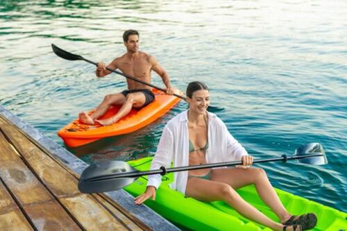 two men are sitting on kayaks on the water at Amaranto Bacalar Hotel Boutique in Bacalar