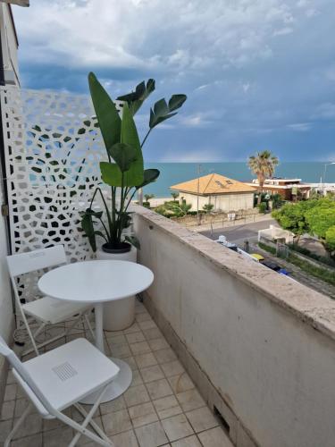 a table and chairs on a balcony with a plant at Cerry's Apartments Fronte Mare - Seaside & Sealight in Fossacesia