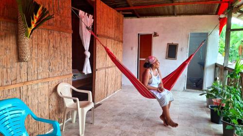 ArusíにあるPosada Palma de Trupaの部屋のハンモックに座る女性