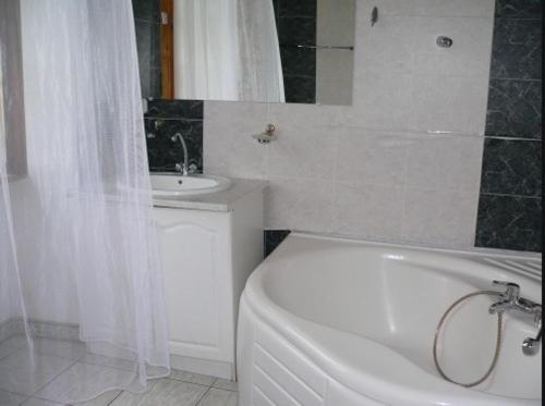a white bathroom with a tub and a sink at Pałac Brody in Brody