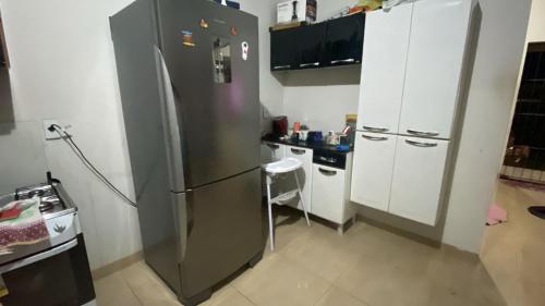a kitchen with a stainless steel refrigerator and white cabinets at Casa para Rondônia Rural Show in Ji-Paraná