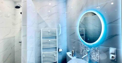 a bathroom with a round mirror and a sink at Contemporary house stadium of france in Saint-Denis
