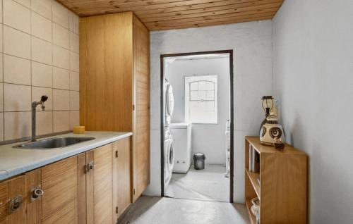 a kitchen with a sink and a door to a bathroom at Two-Bedroom Apartment In Middelfart in Middelfart