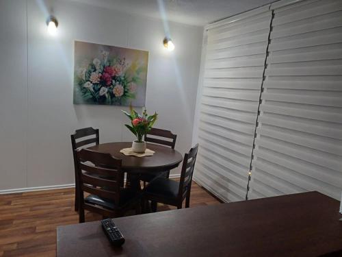 a dining room with a table with a vase of flowers on it at Departamento por día 2 Dormitorios Wi Fi in Chillán