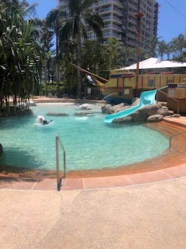a pool with a water slide in a resort at Envy of Surfers Paradise in Gold Coast
