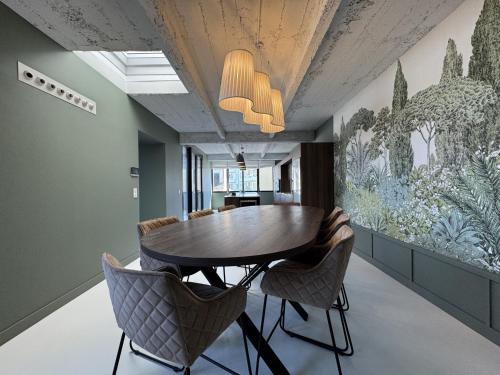 une salle à manger avec une table et des chaises dans l'établissement Stylish Home Base for Your Adventure, au Mans