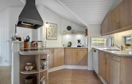 a large kitchen with wooden cabinets and a sink at Three-Bedroom Holiday Home In Assens in Assens