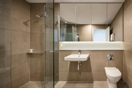雪梨的住宿－聖倫納茲探索公寓，浴室配有卫生间、盥洗盆和淋浴。