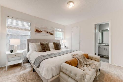 a white bedroom with a large bed and a couch at Austin Home Near Lakeline Mall & Pinballz Austin in Austin