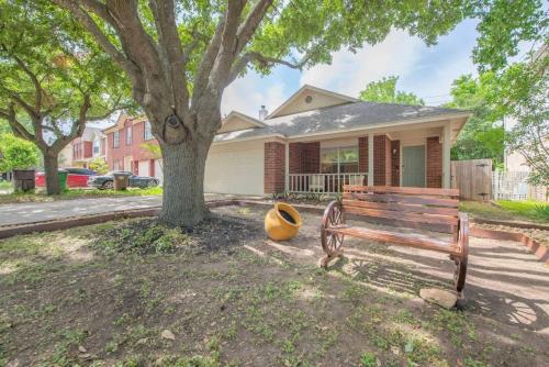 a wooden bench next to a tree in front of a house at Austin Home Near Lakeline Mall & Pinballz Austin in Austin