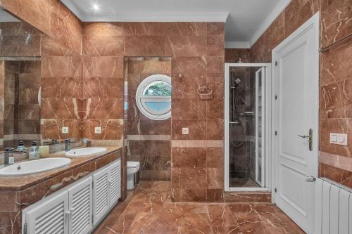 a bathroom with two sinks and a shower at Villa in great location in Marbella
