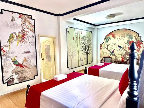 - une chambre avec 2 lits et des peintures sur les murs dans l'établissement VICTORY SECC Hotel, à Hô-Chi-Minh-Ville