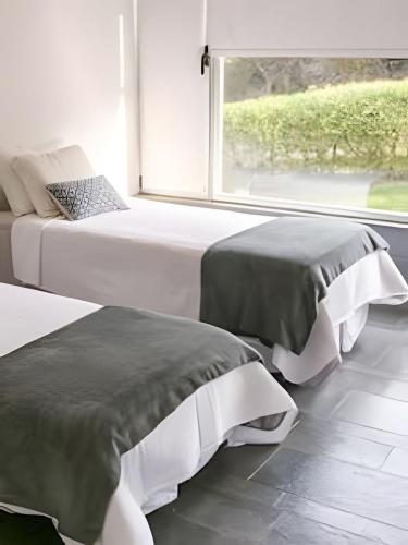 two beds in a room with a window at Sierra Ballena 2 in Punta del Este