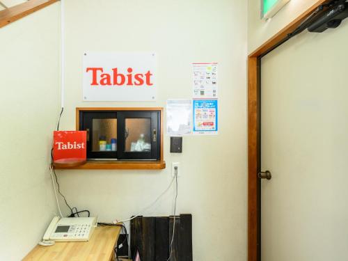 a office with a tablet sign on the wall at Tabist Tatsumi Business Hotel Matsusaka in Matsuzaka