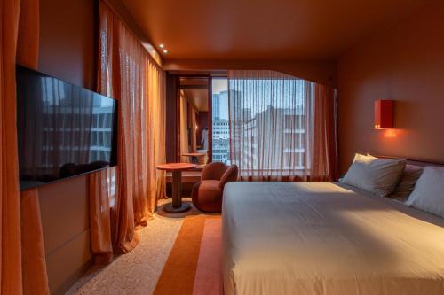 a hotel room with a bed and a large window at Hyde Melbourne Place in Melbourne