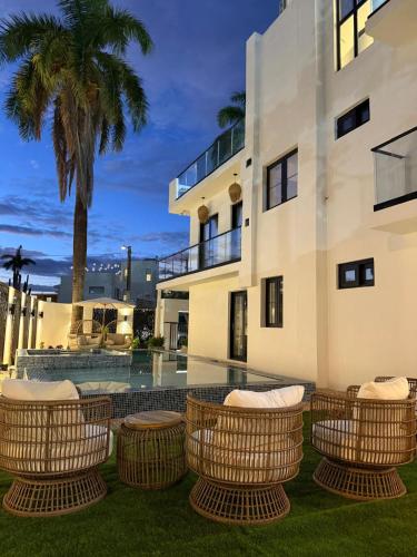 a house with rattan chairs in front of a building at Couples Suites at Ocean Park Beach Club in San Juan