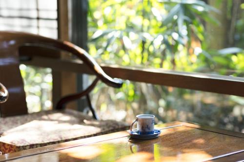 a coffee cup sitting on top of a wooden table at Futsukaichi Hot Spring - Daimaru Besso in Chikushino
