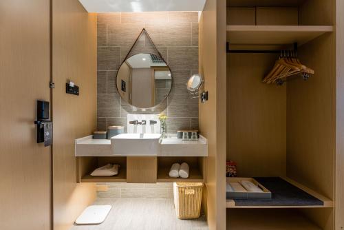 a bathroom with a sink and a mirror at Atour Hotel Suzhou New District Huaihai Street in Suzhou
