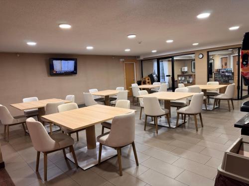a dining room with tables and chairs and a tv at Comfort Inn & Suites Black River Falls I-94 in Black River Falls
