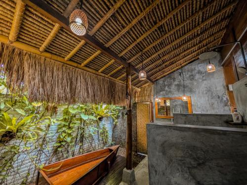 a bathroom with a bench and a large window at Cute Eco Cottage Near 7 Waterfalls in Singaraja