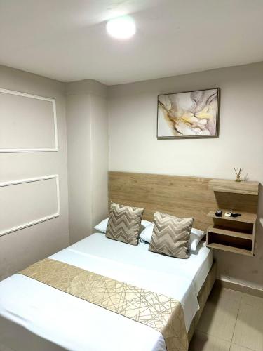 a bedroom with a bed with white sheets at GRAN HORIZON RODADERO Santa Marta in Santa Marta