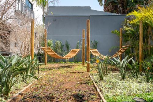 a garden with two chairs and a fence at Studio Aconchegante - Moema in Sao Paulo