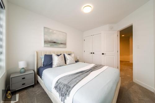 a bedroom with a large white bed and a white cabinet at FreshModernWEMGarageKingBed in Edmonton