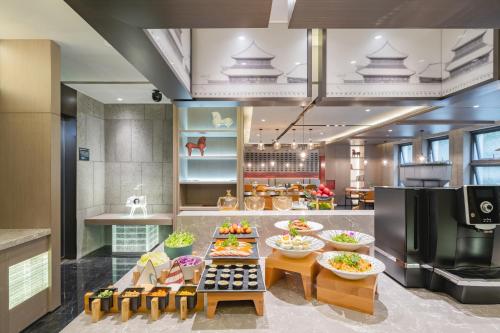 北京市にあるAtour Hotel Beijing Guomao Tuanjie Lakeのビュッフェ形式の料理が展示されているレストラン