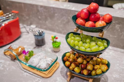 北京市にあるAtour Hotel Beijing Guomao Tuanjie Lakeのテーブルの上に3段に並べられた果物