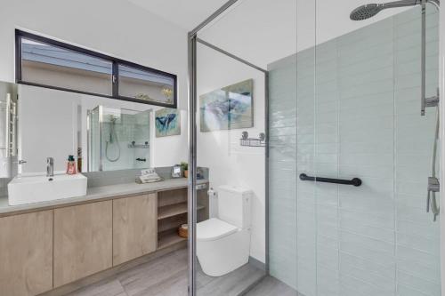 a bathroom with a shower and a toilet and a sink at Lake Front - Outdoor Hot tub in Merimbula