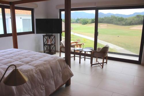 a bedroom with a bed and a view of a golf course at Naisári Residencia Punta de Mita María Bonita in Higuera Blanca