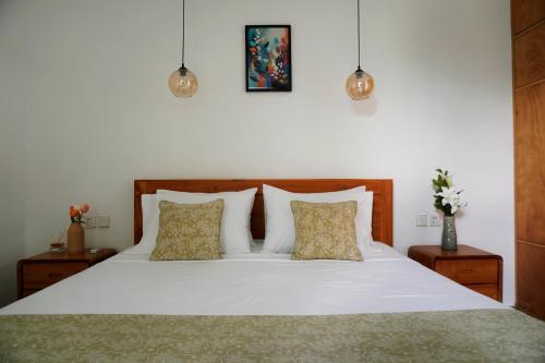 a bedroom with a white bed with two pillows at Tranquil 2BR Pool Villa - Fast WiFi - Work-Friendly - Near Echo Beach in Tumbak Bayuh