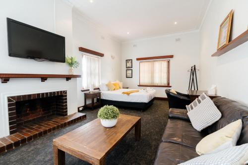 a living room with a couch and a fireplace at Civic Hotel in Perth