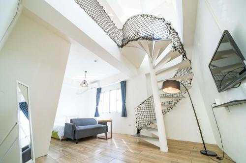 a spiral staircase in a living room with a chair at Songyue Homestay in Yilan City