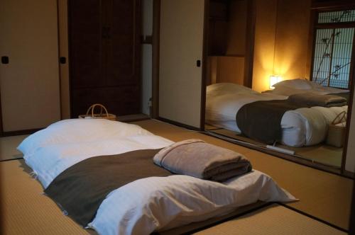 a room with two beds in front of mirrors at Showrai-An 松頼庵 in Nagano
