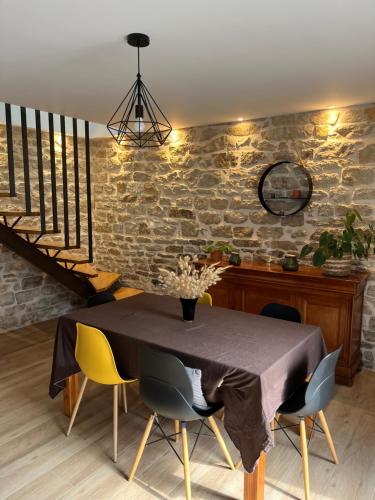 a dining room with a table and yellow chairs at Maison entièrement rénovée, jardin & terrasse à 5min des plages in Combrit