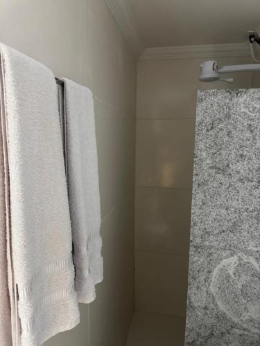 a bathroom with white towels and a shower at Pousada Alameda Boa Vista in Recife
