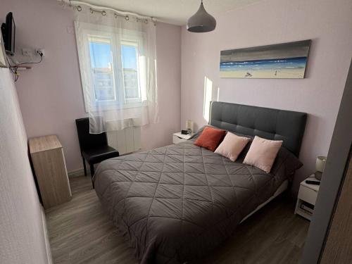 une chambre avec un lit avec deux oreillers dessus dans l'établissement Confortable T2 au Cap d'Agde avec WiFi et parking, animaux acceptés - FR-1-749-103, au Cap d'Agde