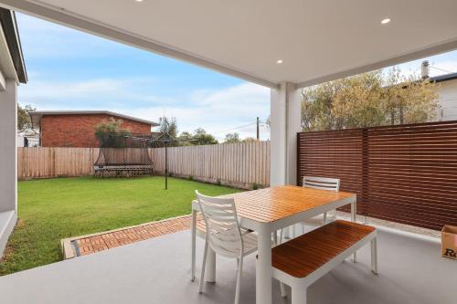 a patio with a table and chairs and a backyard at Taigh Na Mara in Ventnor