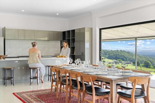 two women in a kitchen with a table with wine glasses at Panorama Farm - 3BD Wilderness Retreat in Bald Knob
