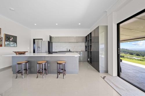 a kitchen with a counter and stools in it at Panorama Farm - 3BD Wilderness Retreat in Bald Knob