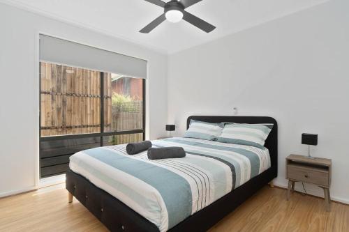 Un dormitorio con una cama con ventilador de techo. en The Station Mornington, en Mornington